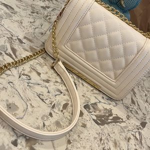 Beige crossbody purse with gold buckle strap